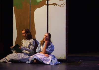 two girls sitting under a tree set