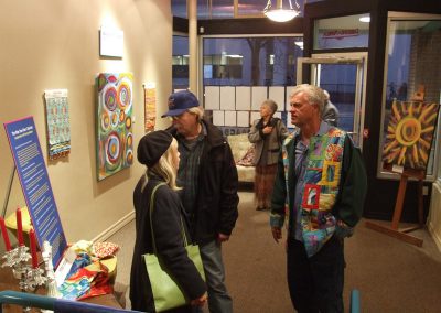 photo of mendoza talking with someone at his art show