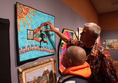 photo of mendoza touching one of his quilting works