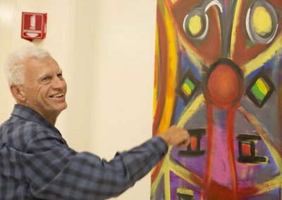 mendoza smiling in front of his painting