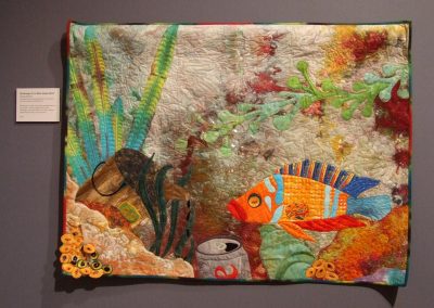 photo of mendoza's quilting work with a fish in a polluted ocean