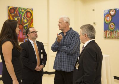 george mendoza speaking with three people