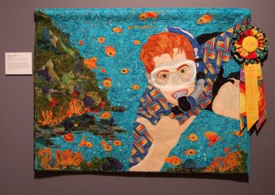 photo of mendoza's quilting work with a man scuba diving