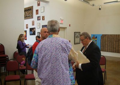 photo of mendoza speaking with two people at the gallery