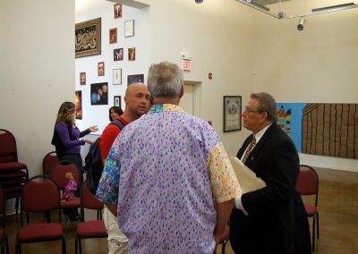 photo of mendoza speaking with two people at the gallery