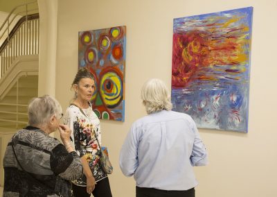 people observing and discussing mendoza's artwork