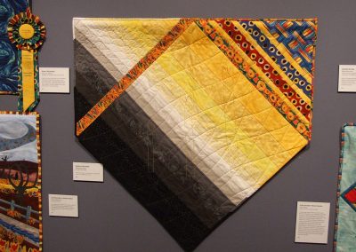 photo of mendoza's quilting work with black, yellow, and grey and abstract lines