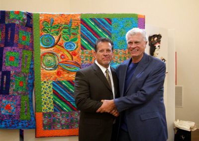 mendoza posed with a man in front of his artwork