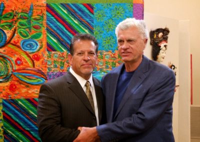 mendoza posed with a man in front of his artwork