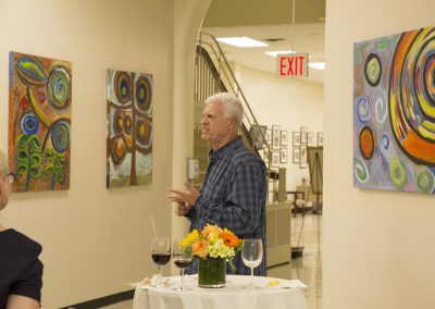 mendoza speaking in front of his artworks