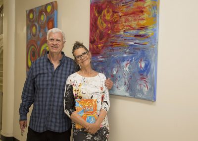 mendoza and a woman posed of his artwork